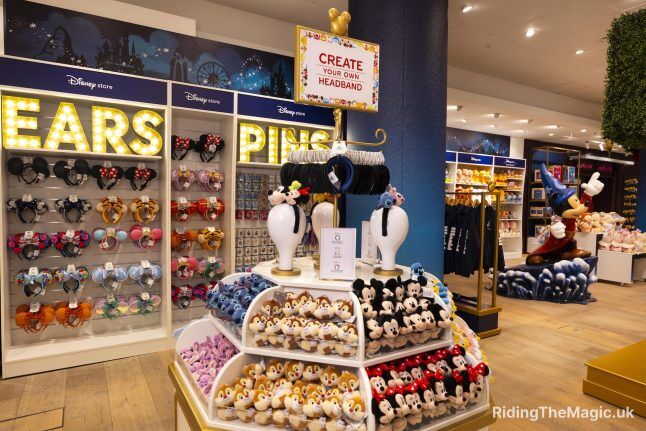 Display tiered with small plush faces above it sign with red writing says Create your own headband behind display light up signs say ears pins headbands below
