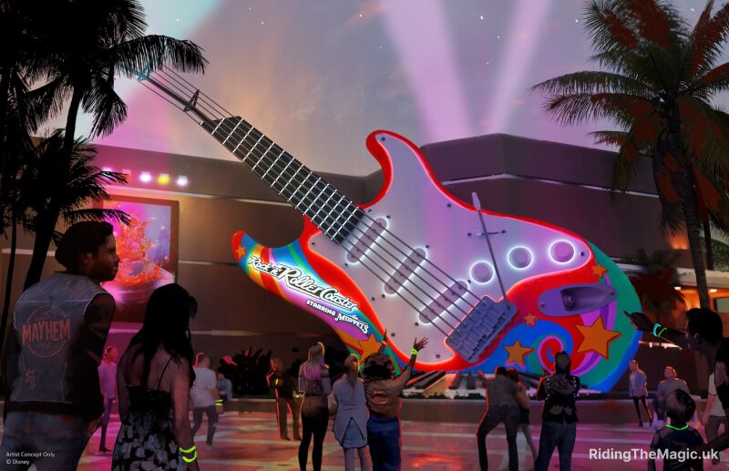 multi coloured giant guitar with words rock n roller coaster starring the muppets with people looking and pointing in courtyard, evening backdrop
