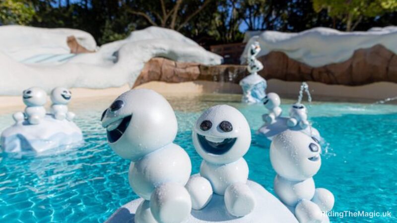 pool crystal blue water in background with three small snow men foregrounded with smiling faces