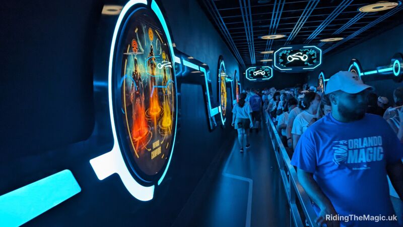 People in the queue for TRON inside with signage on the walls