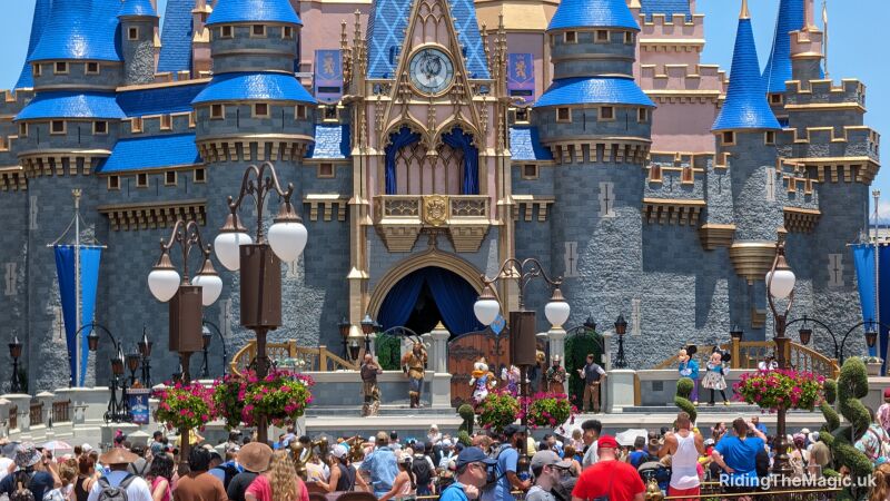 People enjoy a show in front of the castle in Magic Kingdom