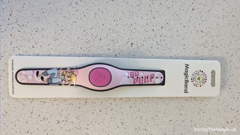 A pink and white Magic Band with a girl on it