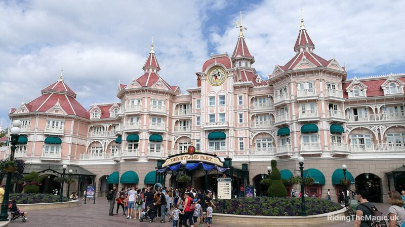 Entrance to Disneyland Paris with a large clock tower and Mickey Mouse on the clock