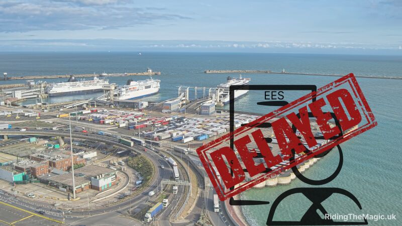 Aerial view of a harbor with ships and trucks, with a red sign saying "EES DELAYED"
