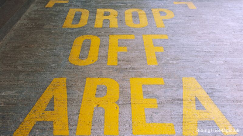 Yellow Drop Off Area text painted on concrete floor at an airport