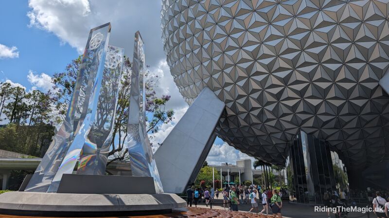 Epcot Center entrance with futuristic design and people walking around it