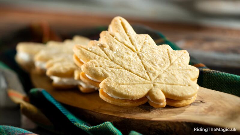 Maple leaf shaped cookies with white frosting and a blue and green plaid cloth