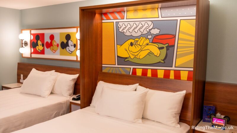 Two twin beds with Mickey Mouse paintings on the wall