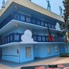 Colorful blue building with cartoon-style decorations, including clouds and silhouettes on the roof.